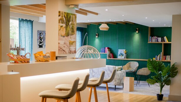 Un intérieur moderne comprenant un bar, des sièges et une bibliothèque.