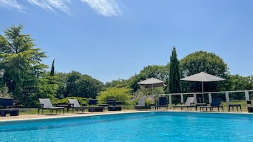 Una piscina al aire libre de temporada, sillones reclinables de piscina