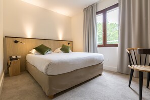 Ylelliset vuodevaatteet, tallelokero huoneessa, työpöytä