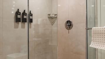 A modern bathroom with a glass shower enclosure, a glass door, and a towel rack.