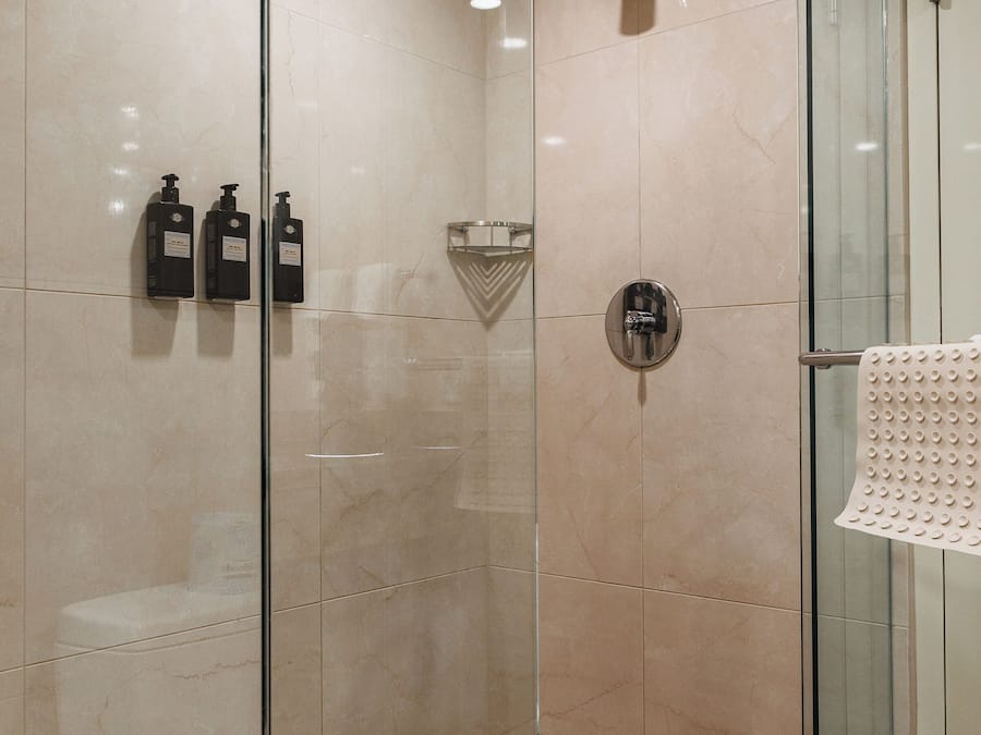 A modern bathroom with a glass shower enclosure, a glass door, and a towel rack.