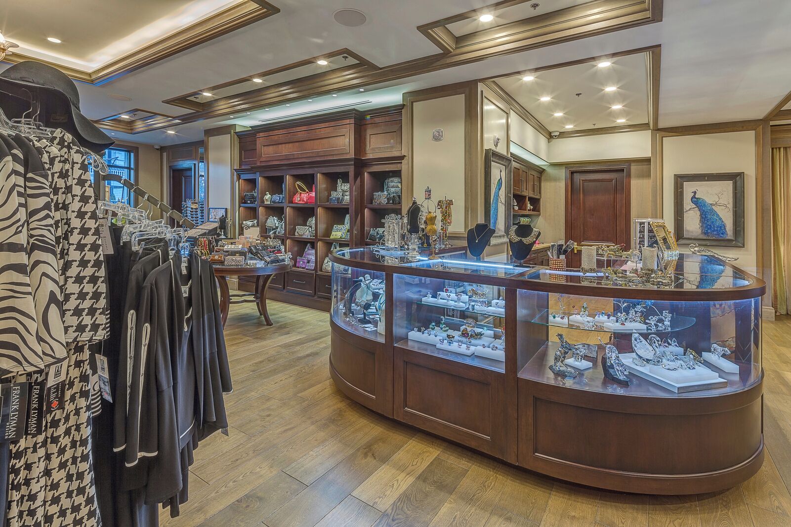 A jewelry store with wooden display cases and clothing racks.