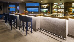 A bar area with a long counter, bar stools, and a view of the city at night. - Hotel Dom Henrique Downtown (Porto)