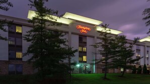 A Hampton Inn hotel with a modern facade, illuminated signage, and a well-maintained lawn. - Hampton Inn Bloomington (Bloomington)