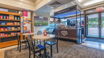 Interior d'una cafeteria amb seients, una petita estanteria de mossegàt i un taulell per beure cafès especials.