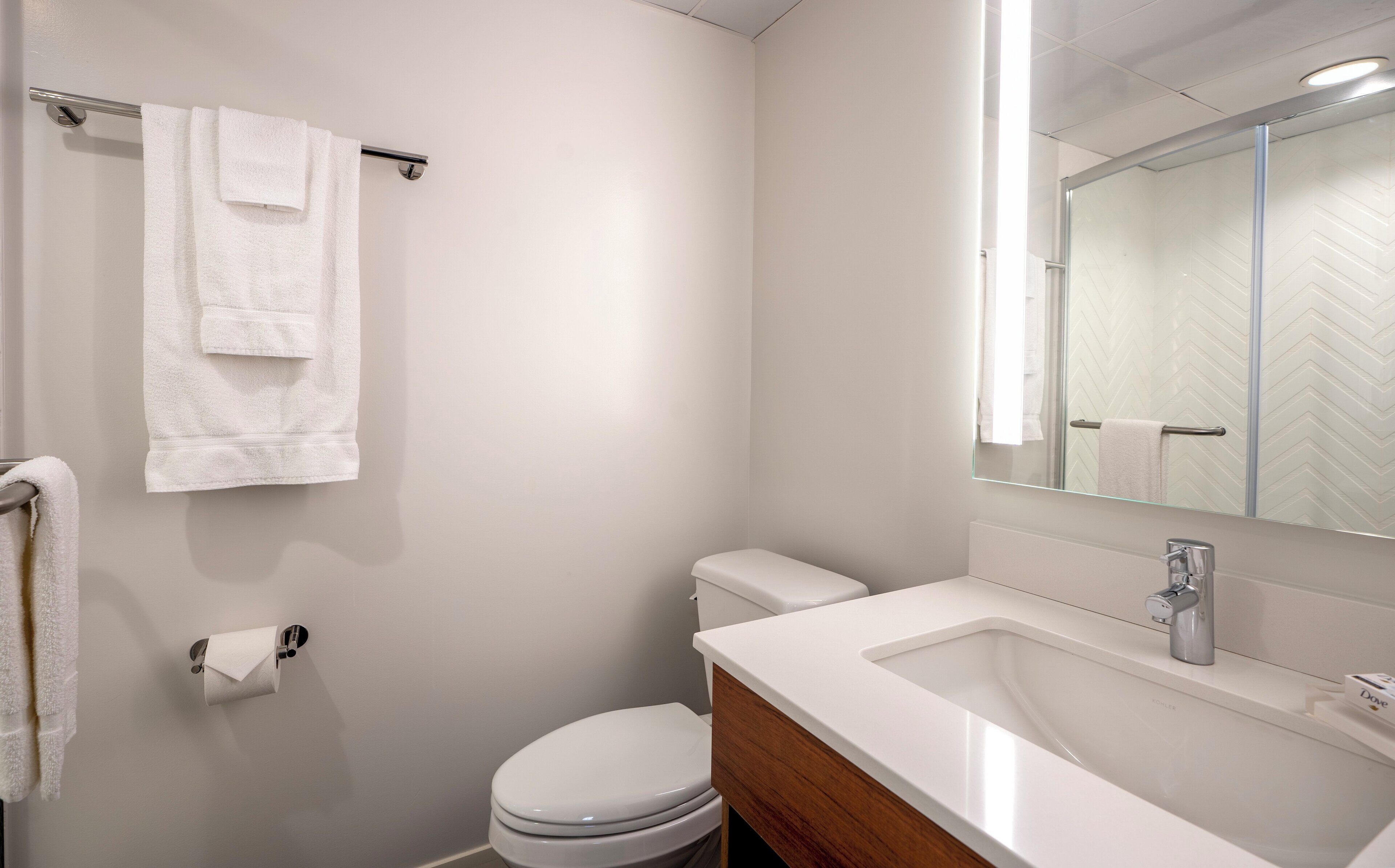 Ein Badezimmer mit Toilette, Waschbecken und Spiegel.