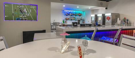 A bar area with a counter, bar stools, and a seating area with tables and chairs.