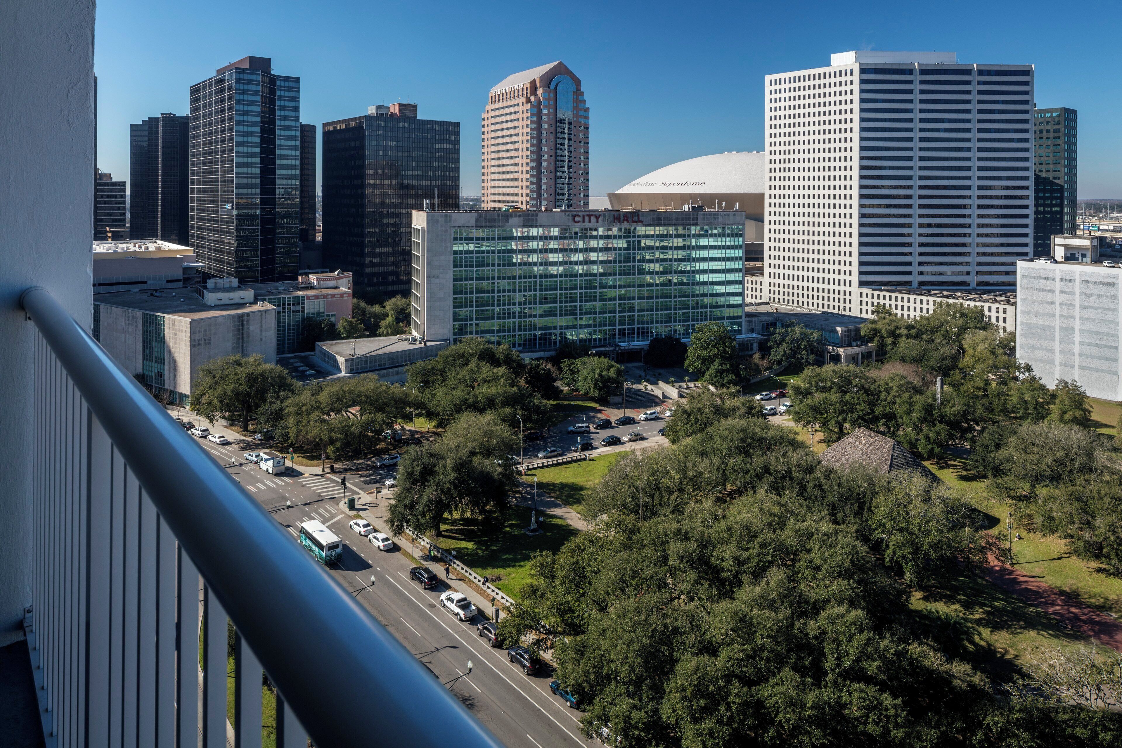 A cityscape with modern buildings, a parking lot, and a street with vehicles.