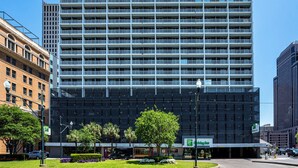 Edificio de un hotel Holiday Inn con diseño moderno, con varios pisos y un cartel grande en la parte superior.