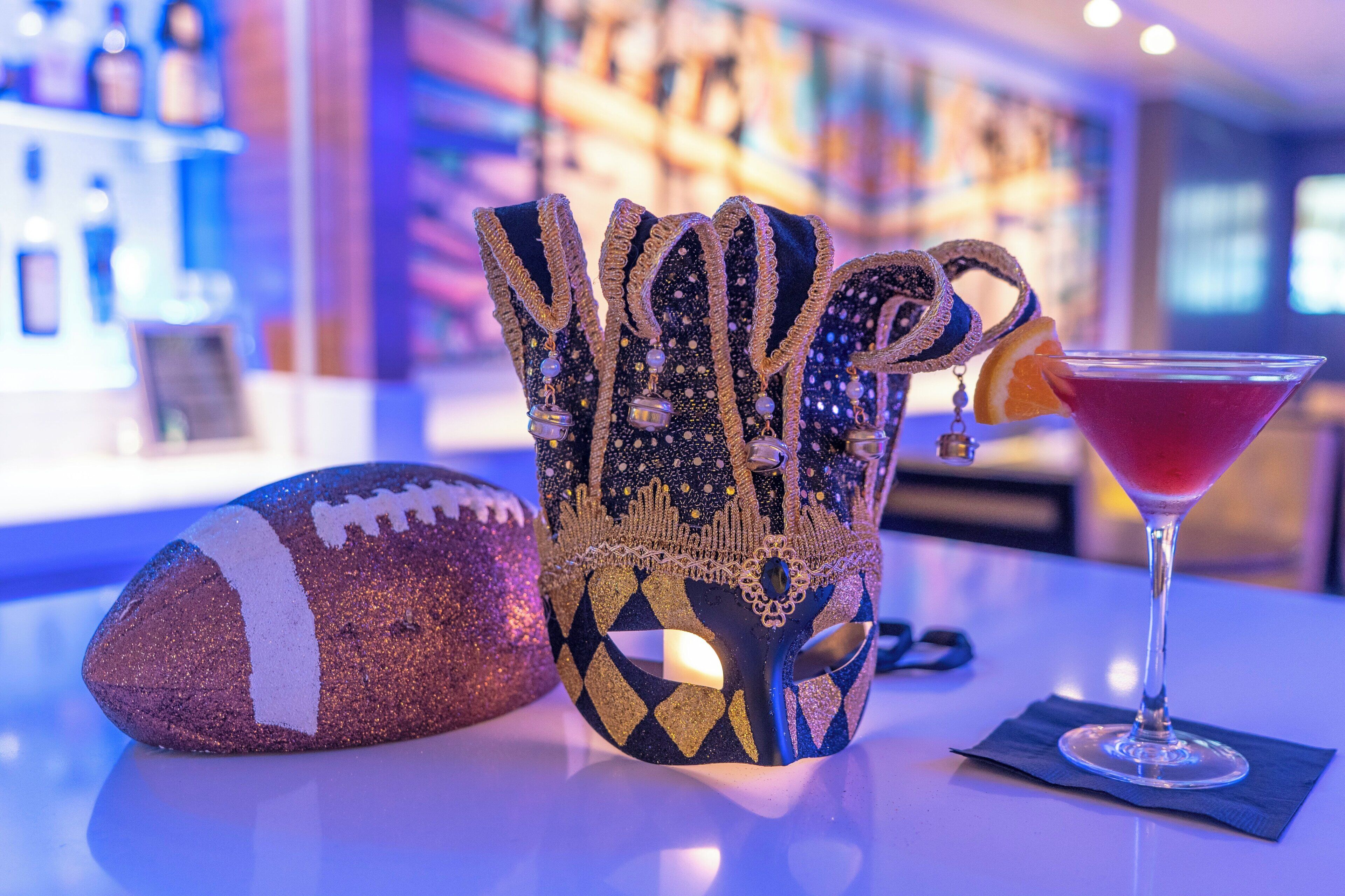 Een bar met een decoratieve kan, een voetbal en een cocktailglas.