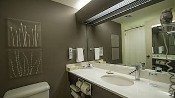 A modern bathroom with a large mirror, a sink, and a toilet.