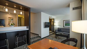 A hotel room with a dining area, a sofa, a TV, and a lamp. - Cambridge Suites Hotel (Halifax)