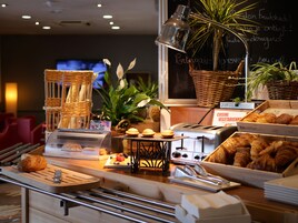 Mostrador de panadería con pan, pasteles y un letrero que indica 'CUISINE VÉGETARIENNE'.