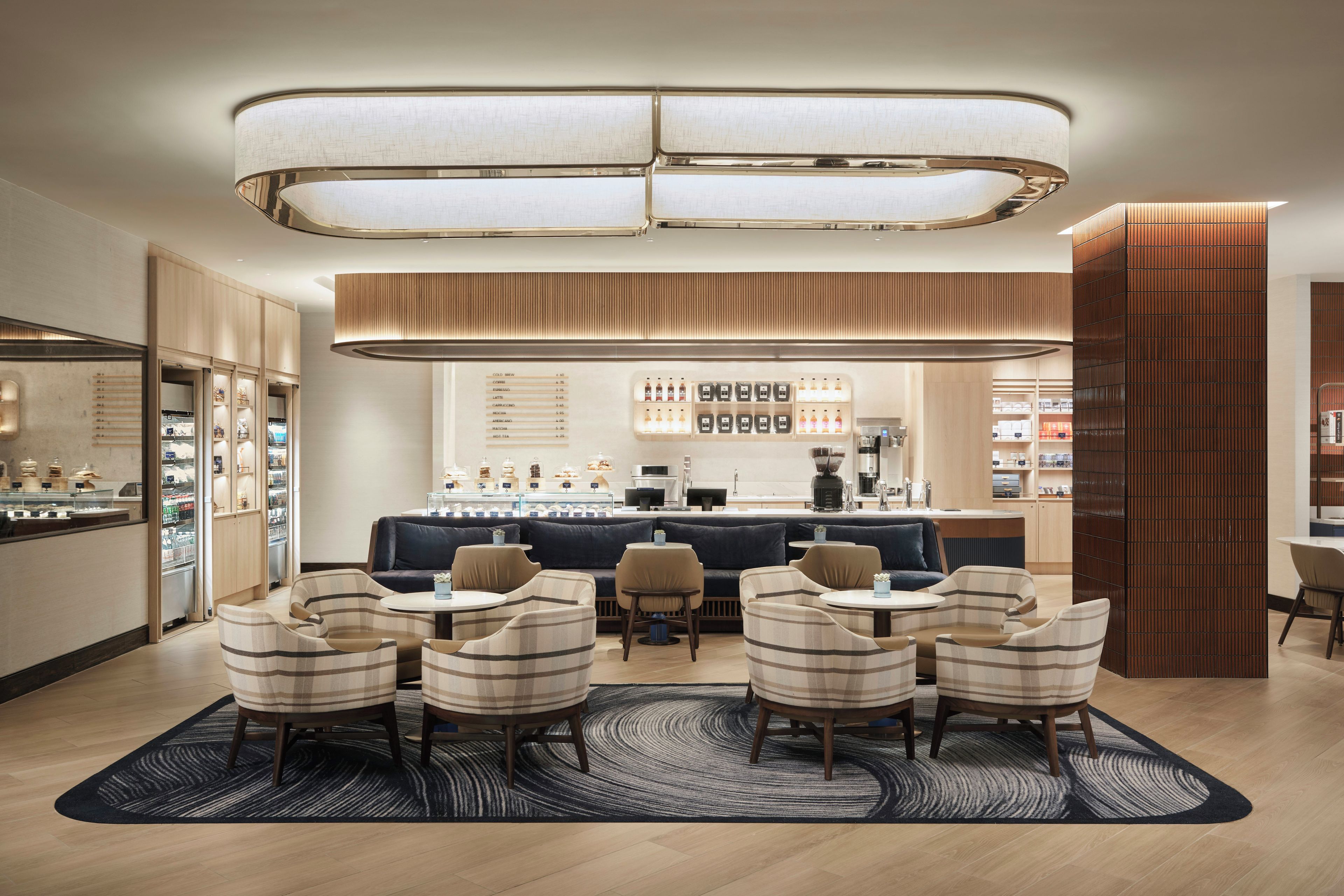 A modern cafe with a bar area, seating, and a menu display.
