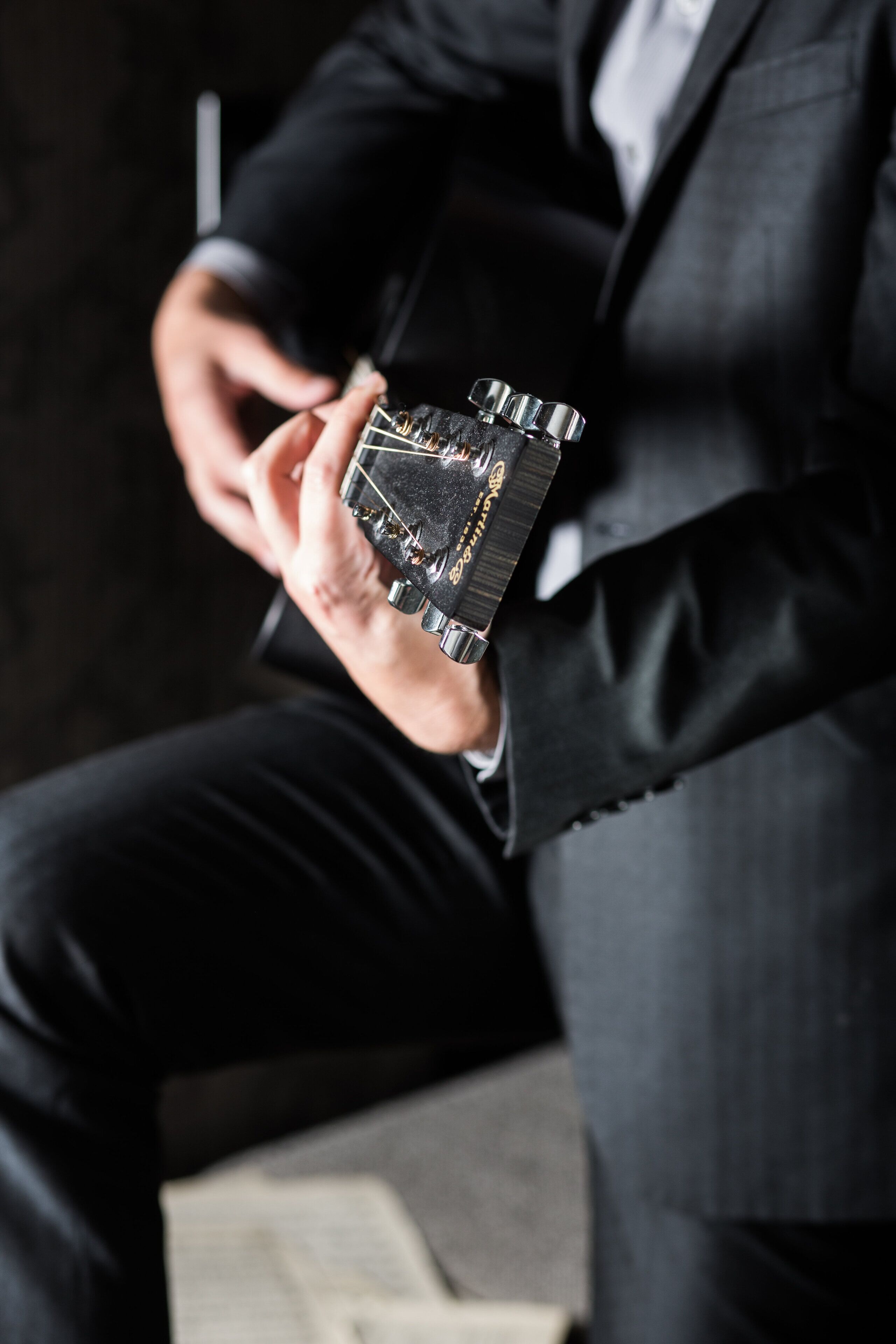A person holding a watch with a black strap and a metallic case.