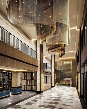 A spacious lobby with a high ceiling, a central staircase, and a modern design. - Loews Nashville Hotel at Vanderbilt Plaza (Nashville)