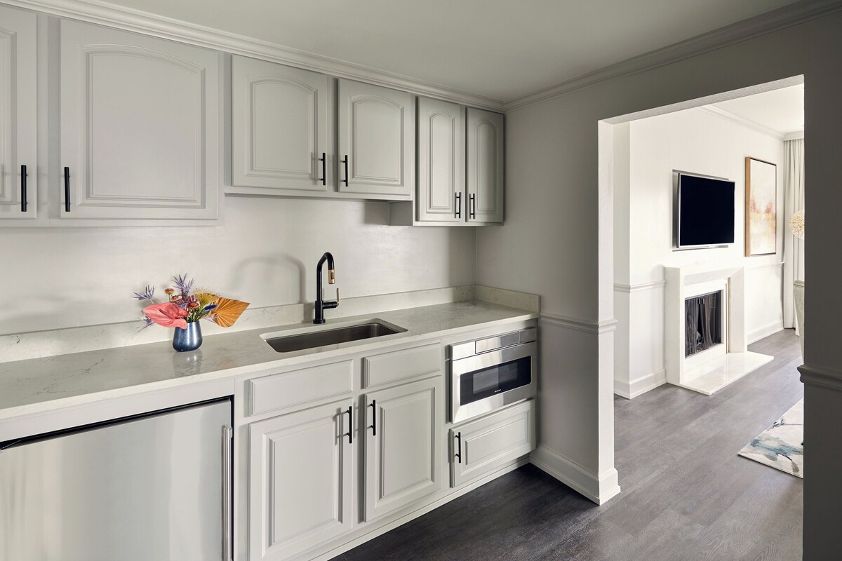 A kitchen with white cabinetry, a sink, and an oven.