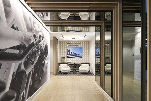 A modern lobby with a large poster, two white chairs, and a 'Nashville' sign. - Loews Nashville Hotel at Vanderbilt Plaza (Nashville)