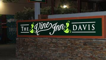 Une enseigne pour le pub The Vine Inn Davis, avec un mur en briques et une structure en forme de pergola.