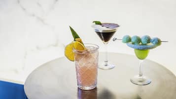 Three different cocktails on a round table with a marble background.
