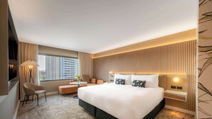 A hotel room with a large bed, a sofa, a desk, and a chair. - PARKROYAL Parramatta (Parramatta)