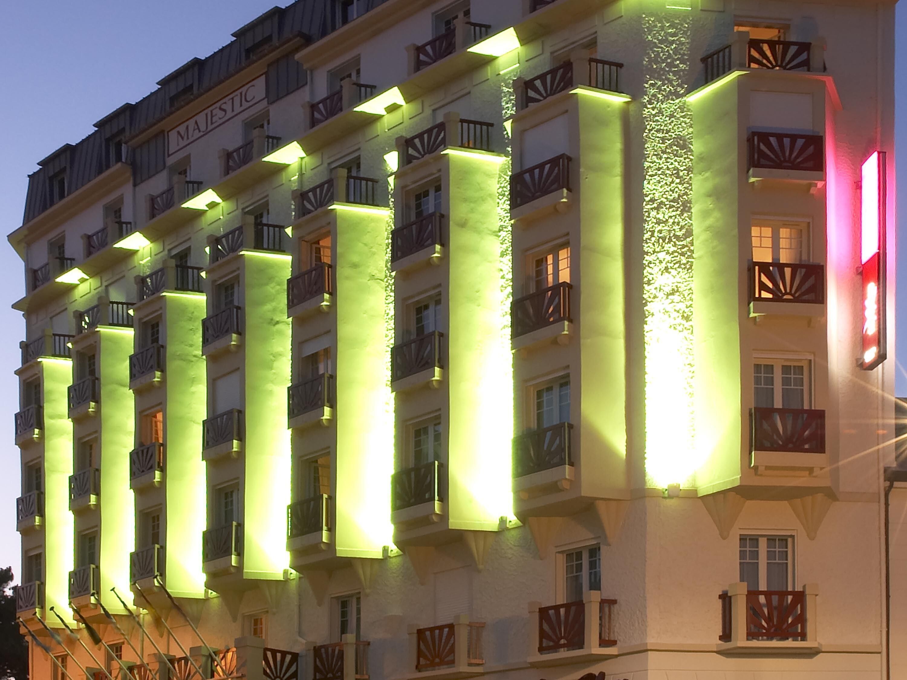A multi-story hotel with illuminated vertical columns and balconies.