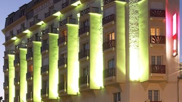 A multi-story hotel with illuminated vertical columns and balconies.