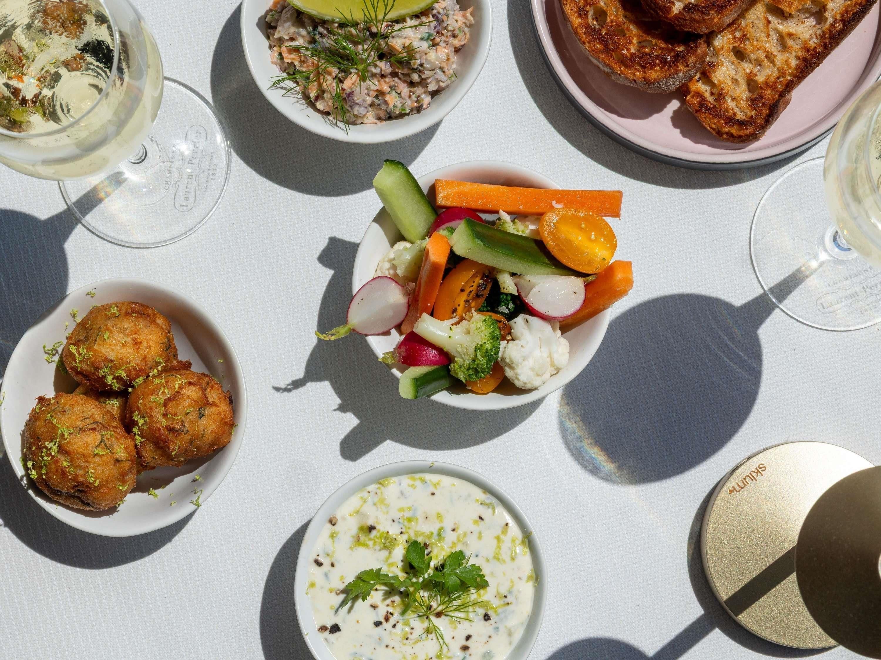 A table with various dishes including a salad, bread, and a creamy soup.