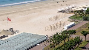 A beach with a clear sky, a sandy shore, and a building with a roofed area. - Mercure La Baule Majestic (La Baule-Escoublac)