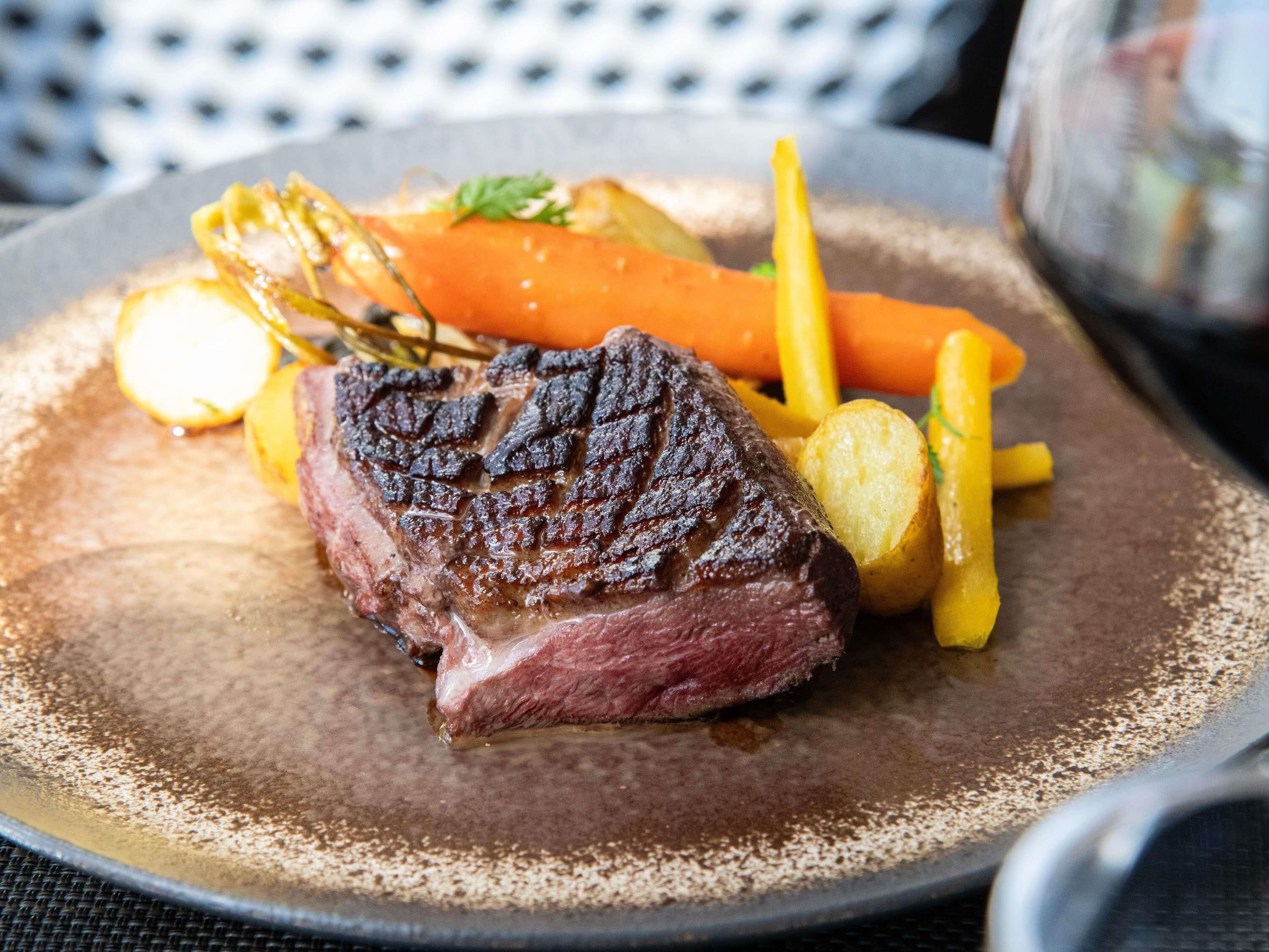 A steak with vegetables on a plate.