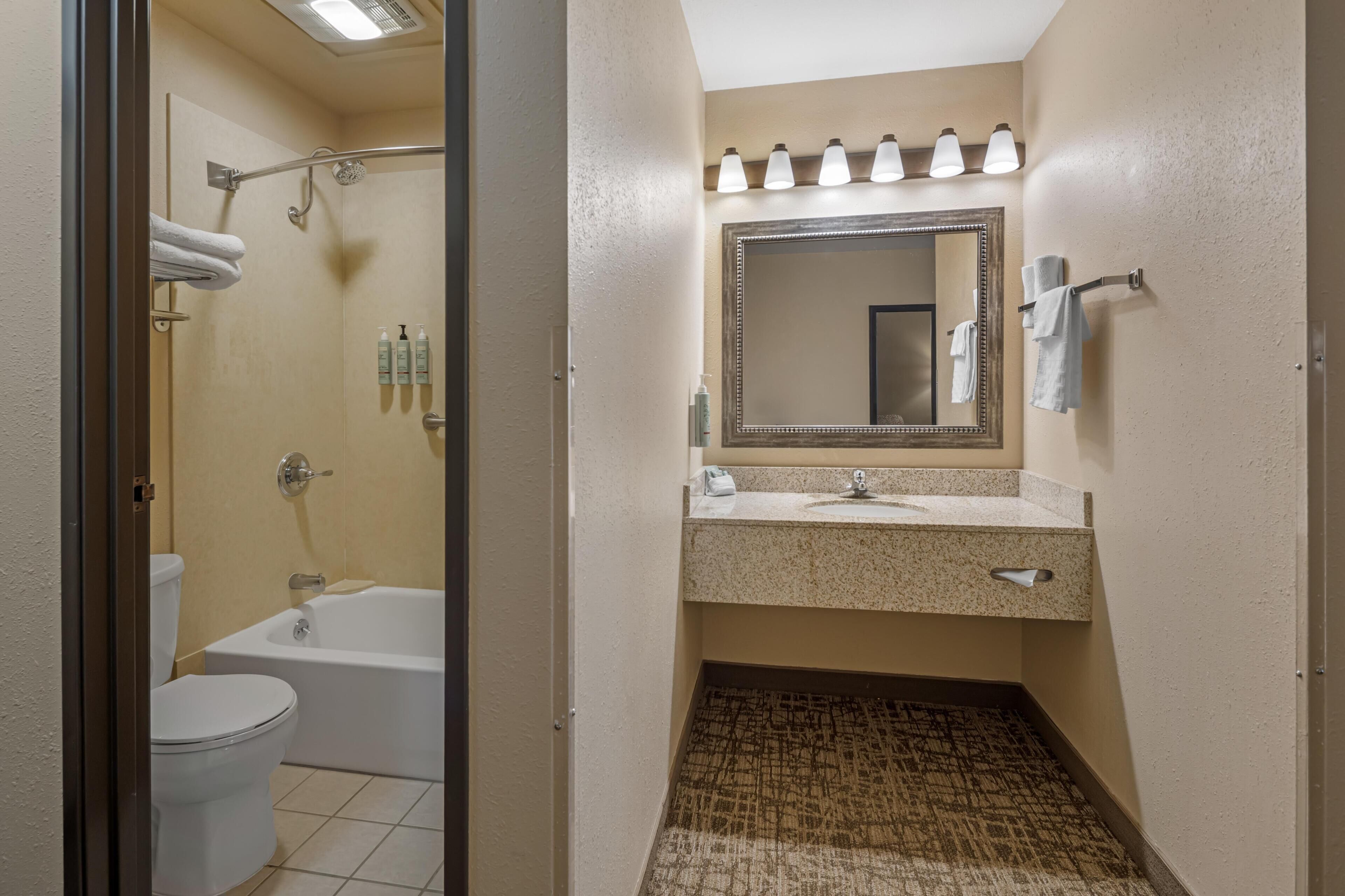 Ein Badezimmer mit Badewanne, Toilette, Waschbecken und Duschbereich.