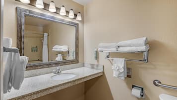 A bathroom with a sink, mirror, towel rack, and toilet.