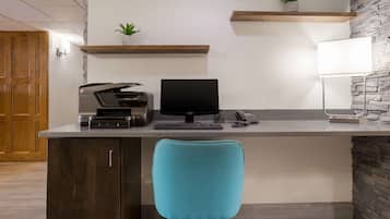 A modern office desk with a computer, printer, and telephone.