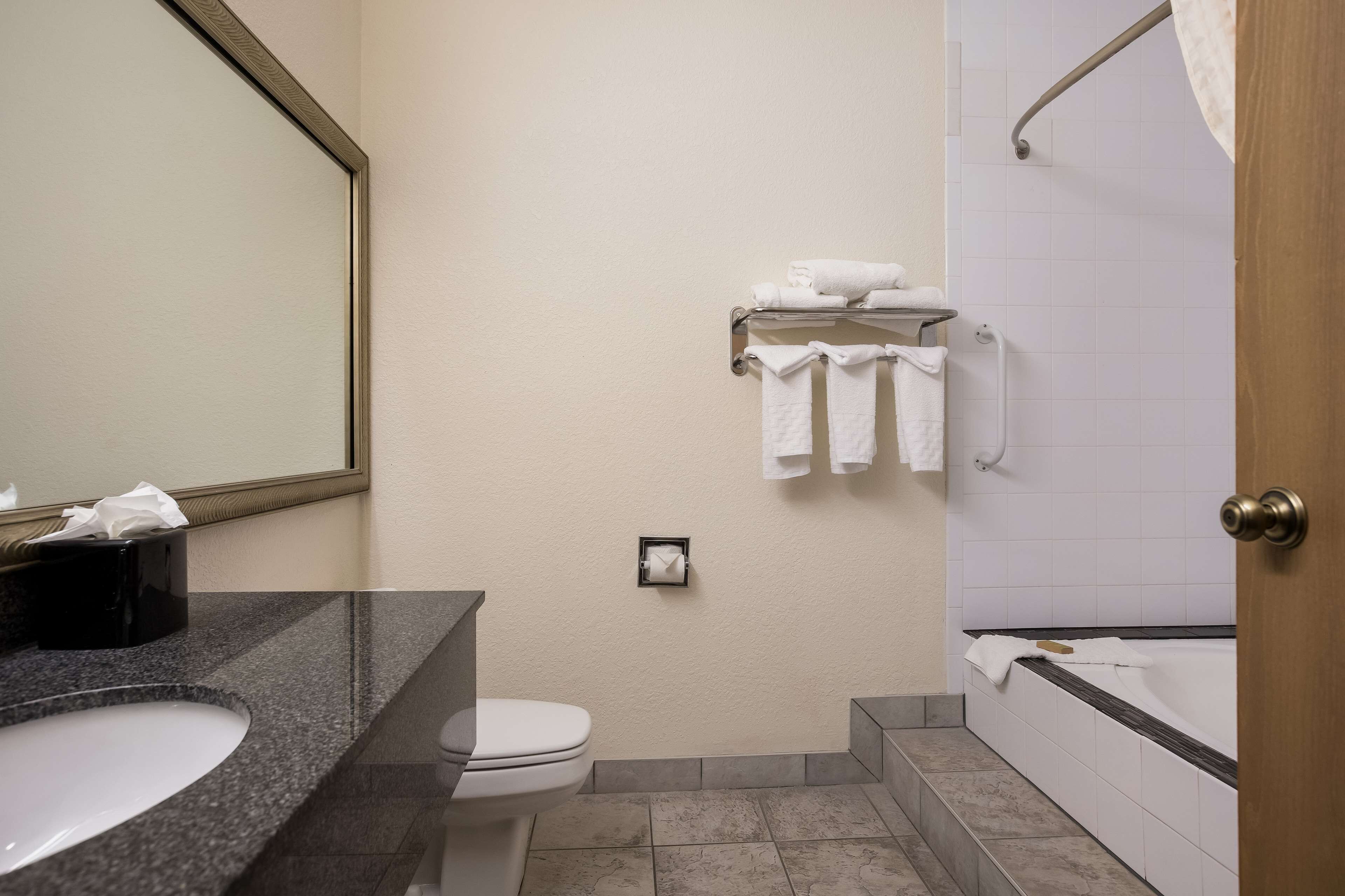 Un baño con lavamanos, inodoro, toallero y bañera.