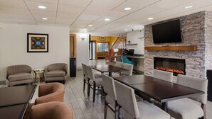A modern indoor space with a fireplace, a flat-screen TV, and comfortable seating. - Best Western Kendallville Inn (Kendallville)