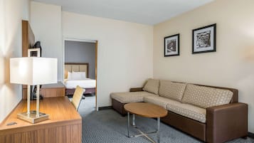 Ein Hotelzimmer mit einer Couch, einem kleinen Tisch, einer Lampe und zwei gerahmten Bildern an der Wand.