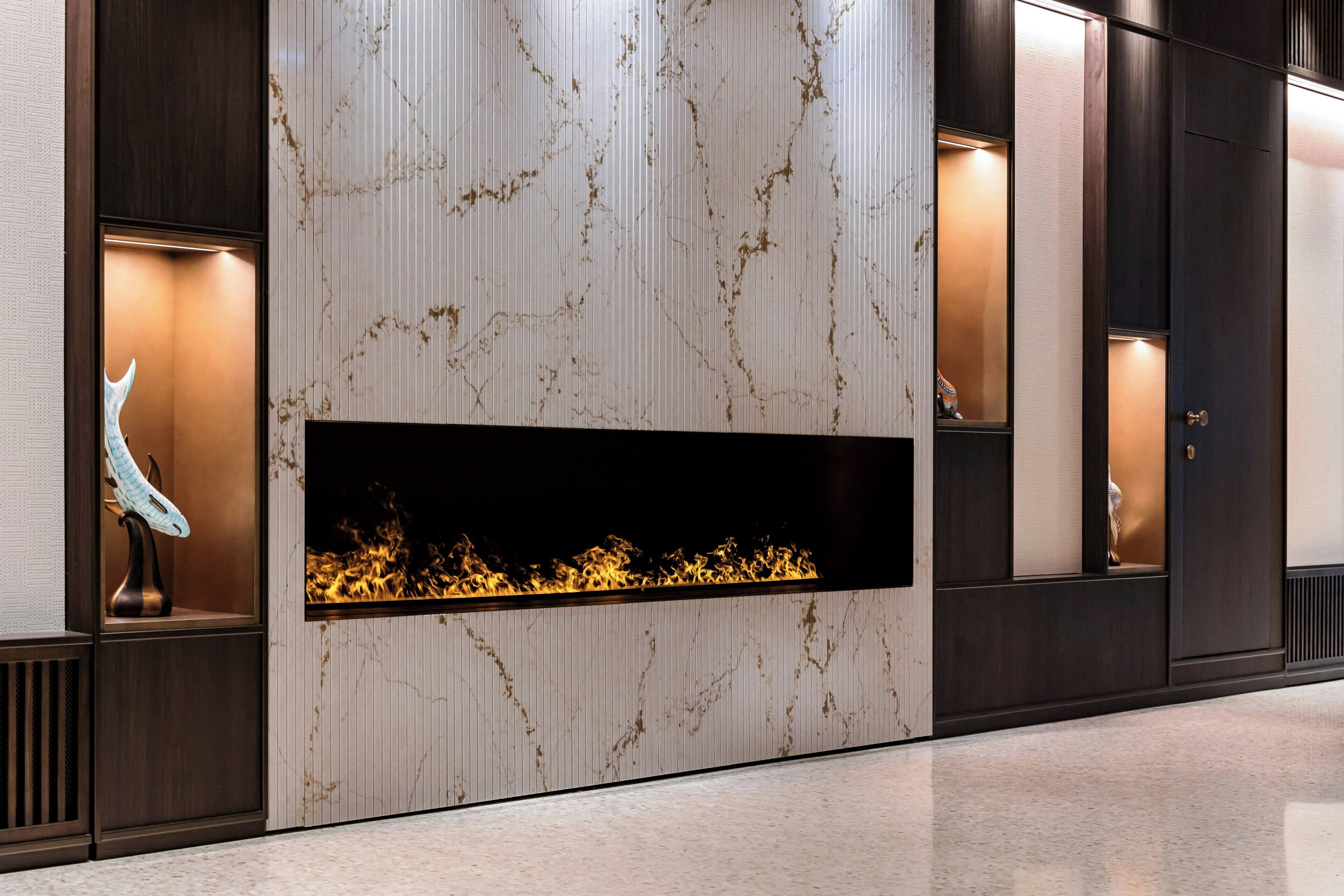 Un interior moderno con chimenea, paneles de madera oscura y un diseño de pared que imita el mármol.