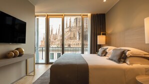 A hotel room with a large bed, a TV, and a view of a cathedral. - Rosa Grand Milano - Starhotels Collezione (Milan)