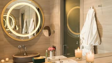 Un bagno moderno con uno specchio rotondo, un lavandino e un porta asciugamani.