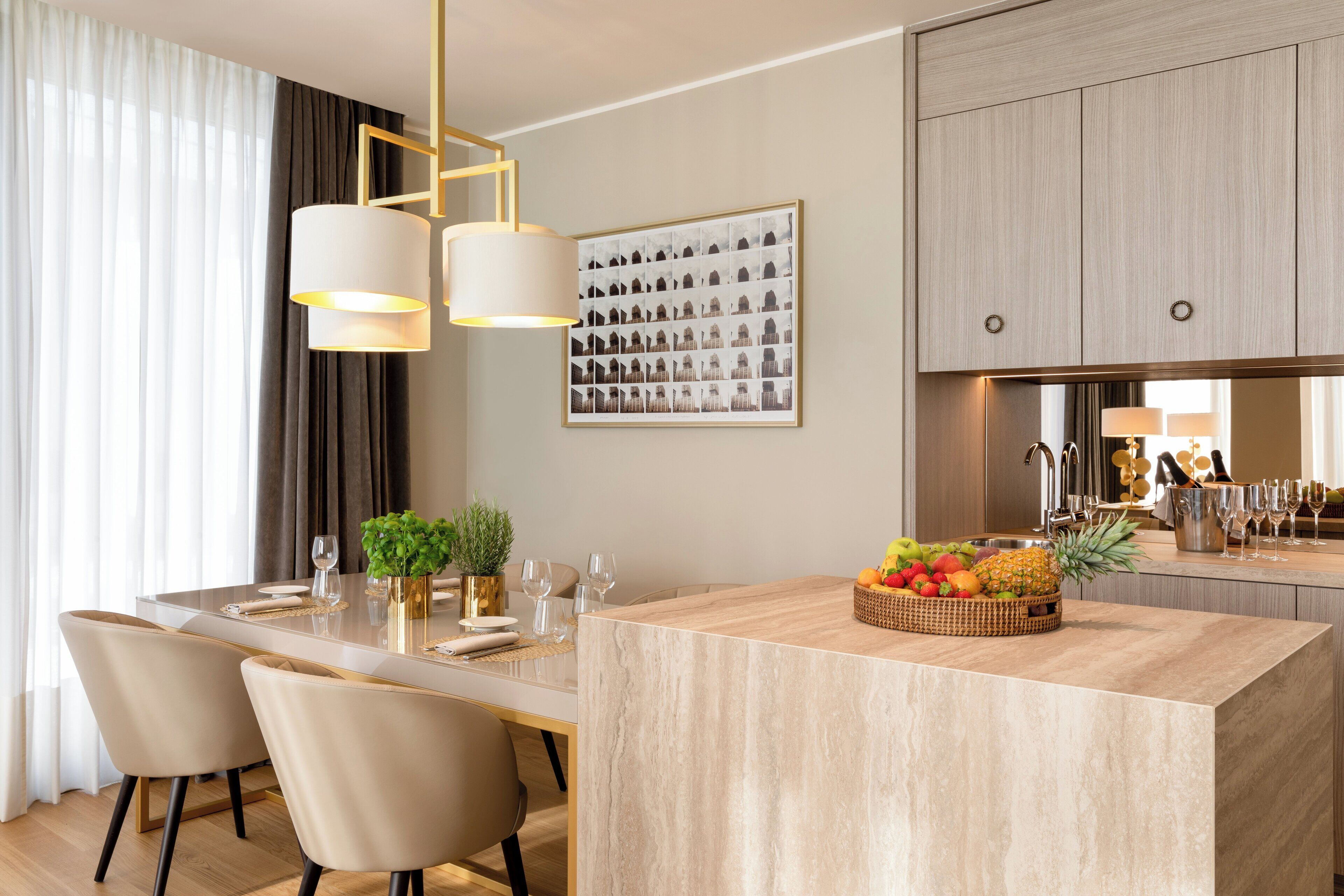 A modern kitchen with a central island, a dining area with chairs, and a large window with curtains.