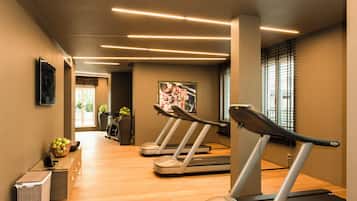 A gym with treadmills, a reception desk, and a potted plant.