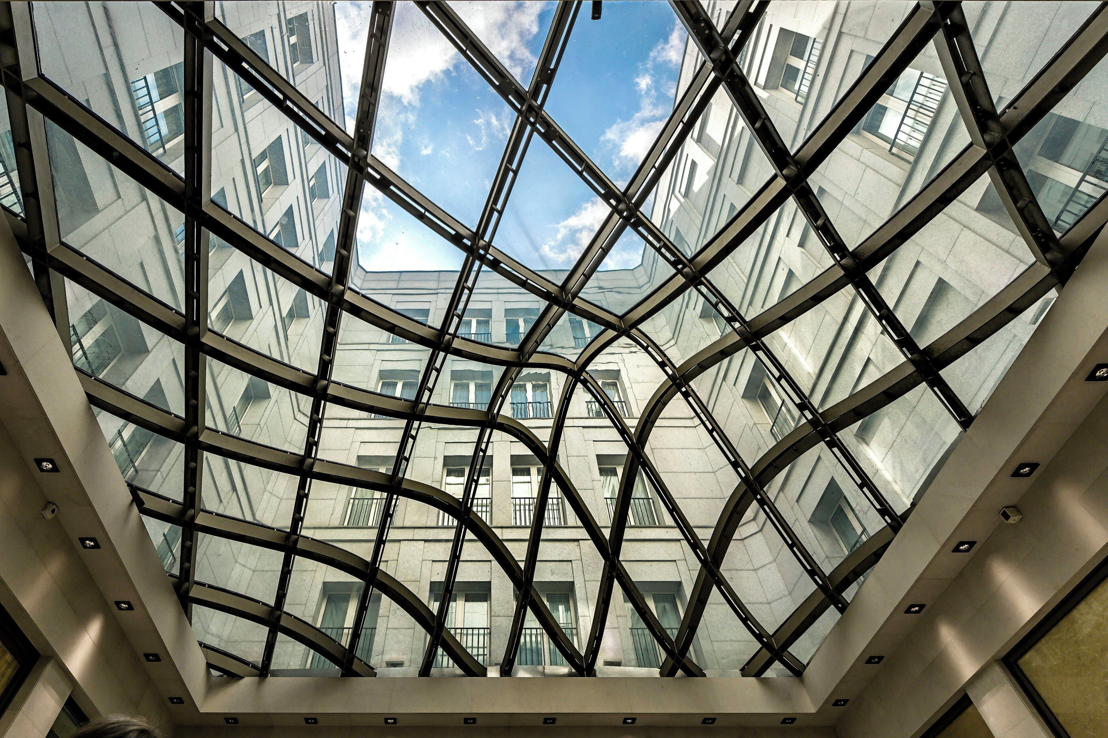 A modern building with a glass facade and a geometric metal framework.