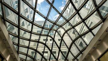 A modern building with a glass facade and a geometric metal framework.