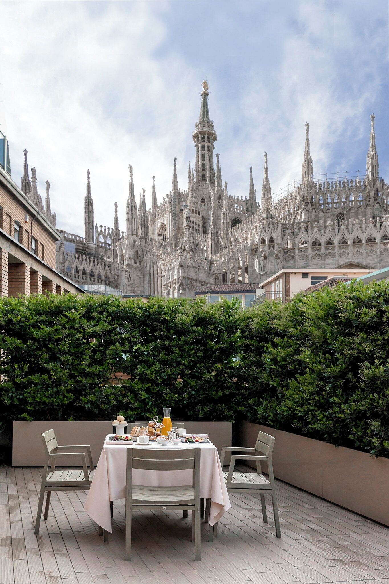 A dining area with a table set for two, overlooking a Gothic-style cathedral.