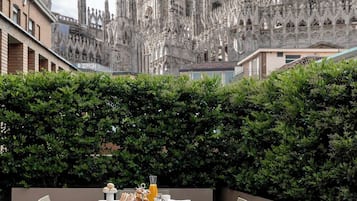 A dining area with a table set for two, overlooking a Gothic-style cathedral.