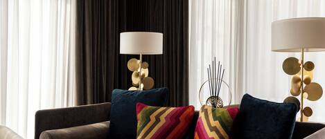 A modern living room with a sofa, decorative pillows, and two lamps.