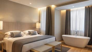 Een moderne hotelkamer met een groot bed, een badkuip en een bankje.