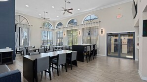 A spacious restaurant with high ceilings, large windows, and modern furniture. - Baymont by Wyndham Orlando East (Orlando)
