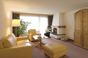 Exclusive Suite | Living area | Flat-screen TV, fireplace, heated floors - Silvretta Parkhotel (Klosters-Serneus)