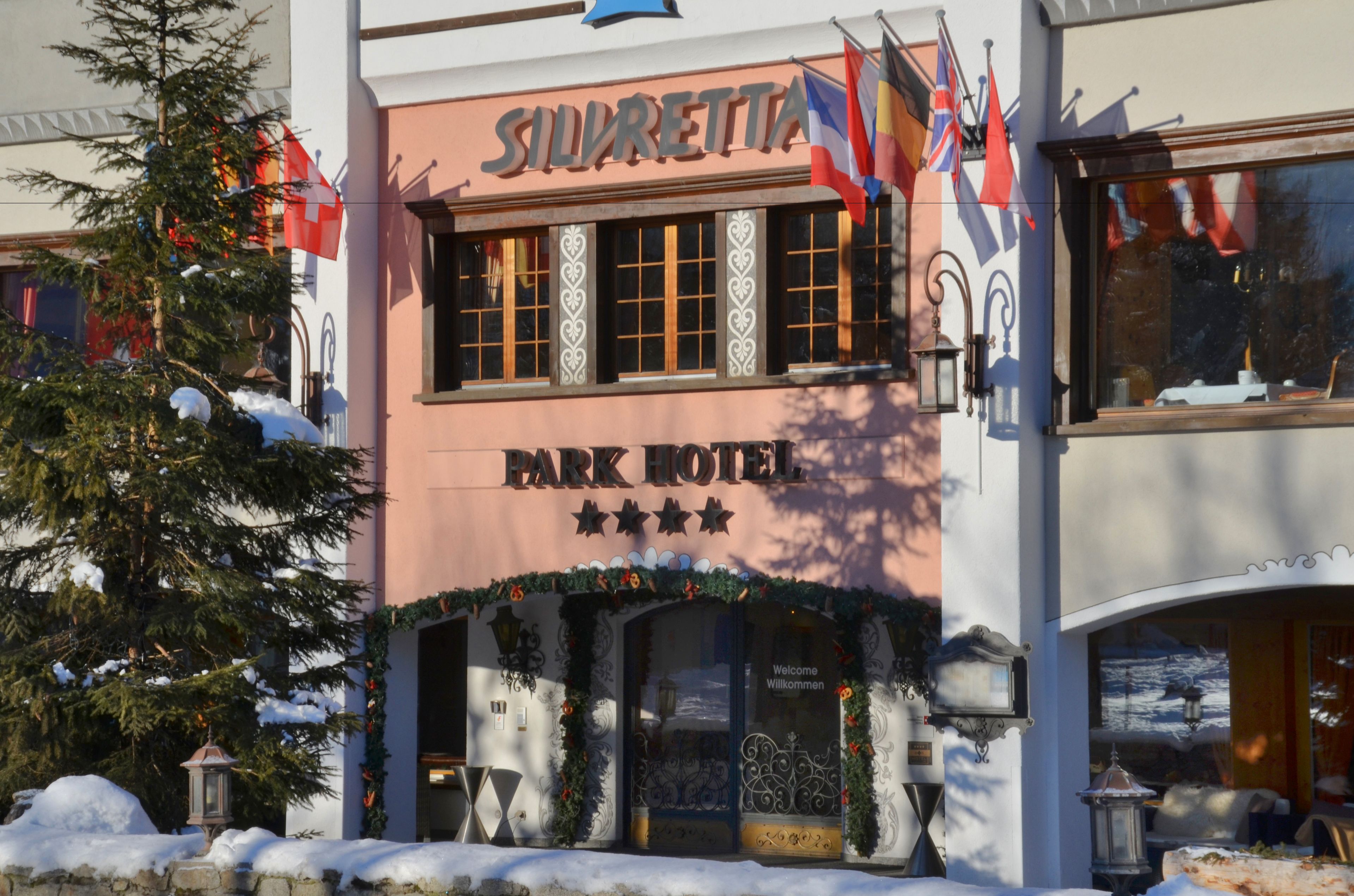 El exterior del Hotel Silvretta Park, con un estilo arquitectónico clásico, destaca una entrada imponente con un arco decorativo y un cartel que dice "Silvretta Park Hotel".